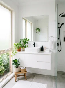 Minimal white bathroom with green plants and black accents