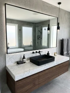 Black sink contrasted with white marble countertop in elegant bathroom
