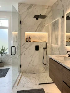 Black shower fixtures paired with elegant marble shower niche
