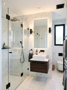 Small black and white marble bathroom with bright lighting