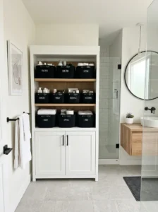 Black baskets in white cabinet bathroom